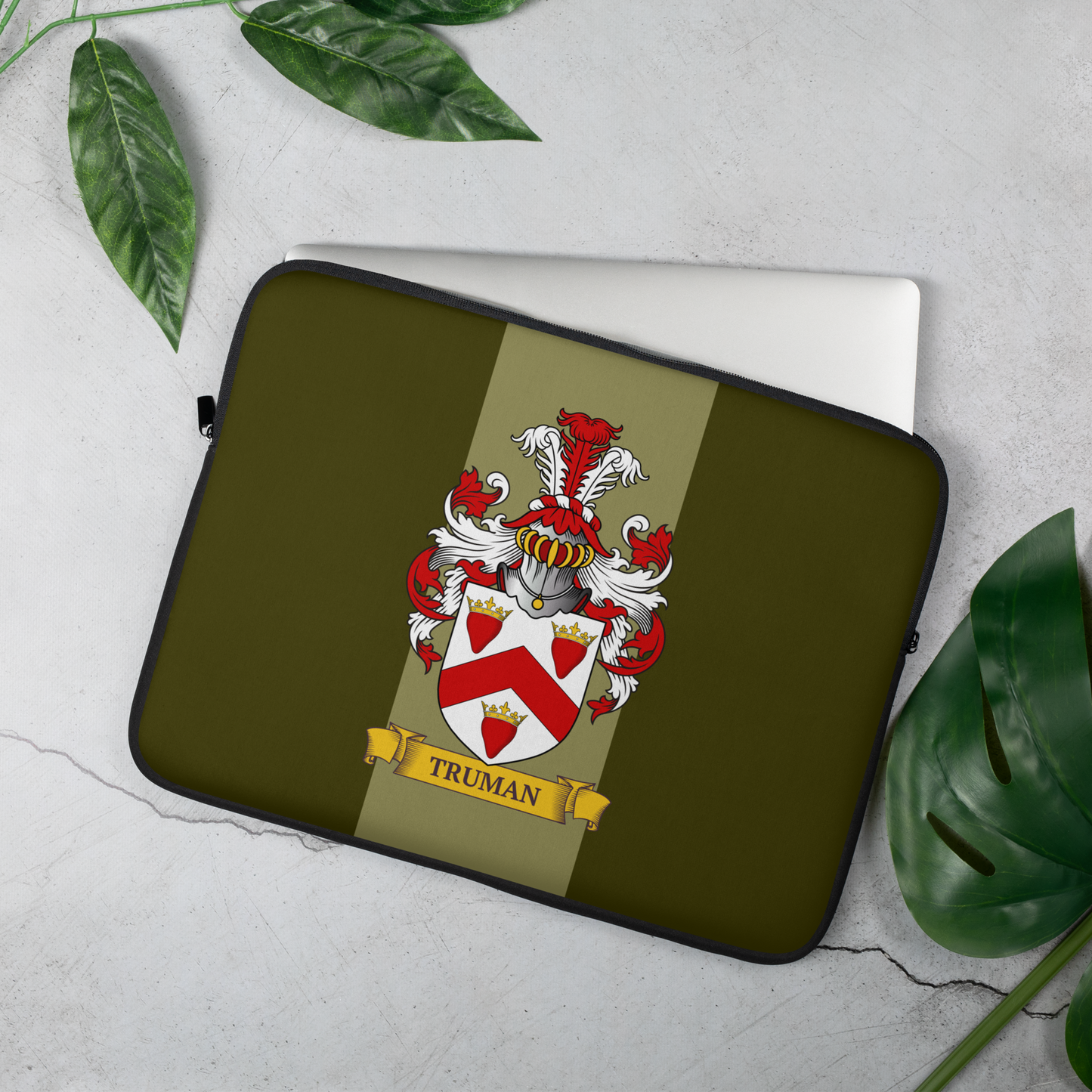 Green Laptop sleeve with a coat of arms design on a light gray background with green leaves.