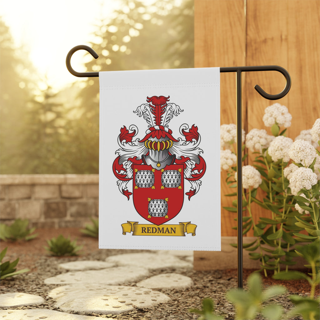 Personalized garden flag with a red and white coat of arms design on a metal rod outdoors.