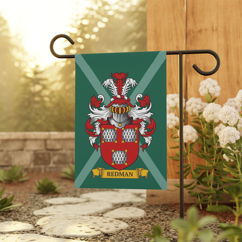 Decorative garden flag with a red and white coat of arms on a green background, featuring a customized last name, attached to a garden flagpole with a blurred natural background.