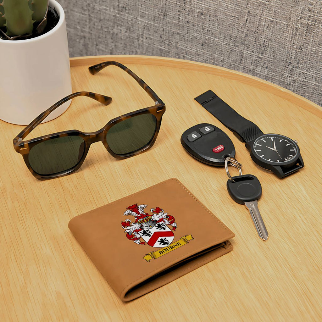 Personalized brown wallet with coat of arms design, sunglasses, car keys, and watch on a wooden table.