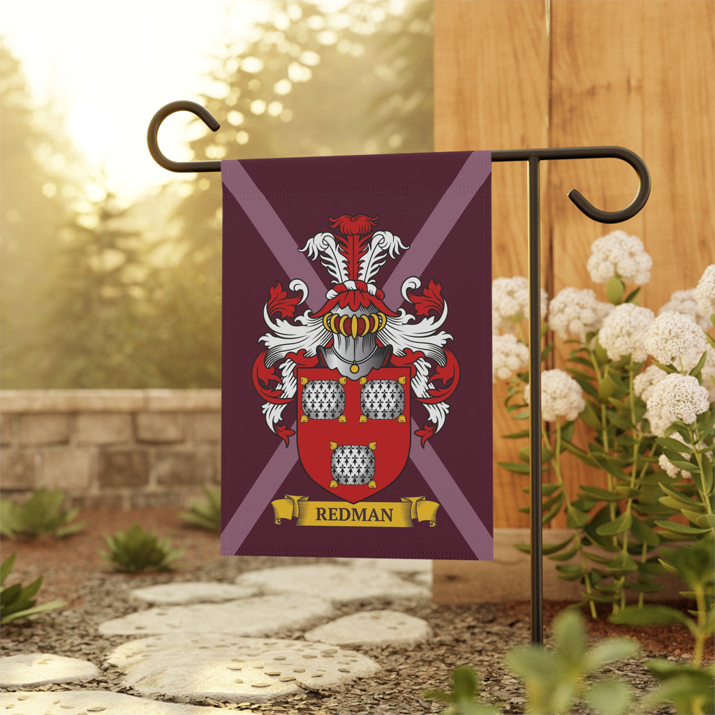 Maroon family crest garden flag with customized last name on a garden flagpole against a natural background