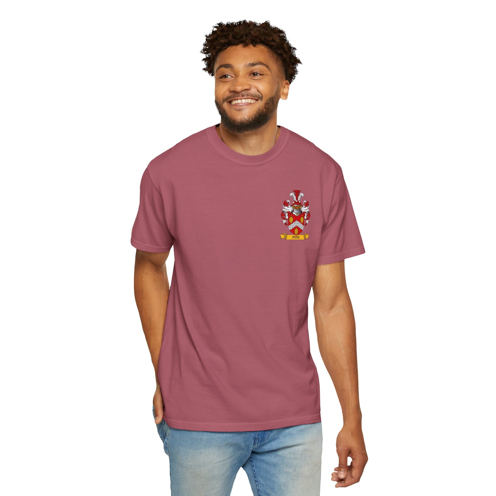 Young man wearing a Garment-Dyed  maroon t-shirt printed with his coat of arms on a white background