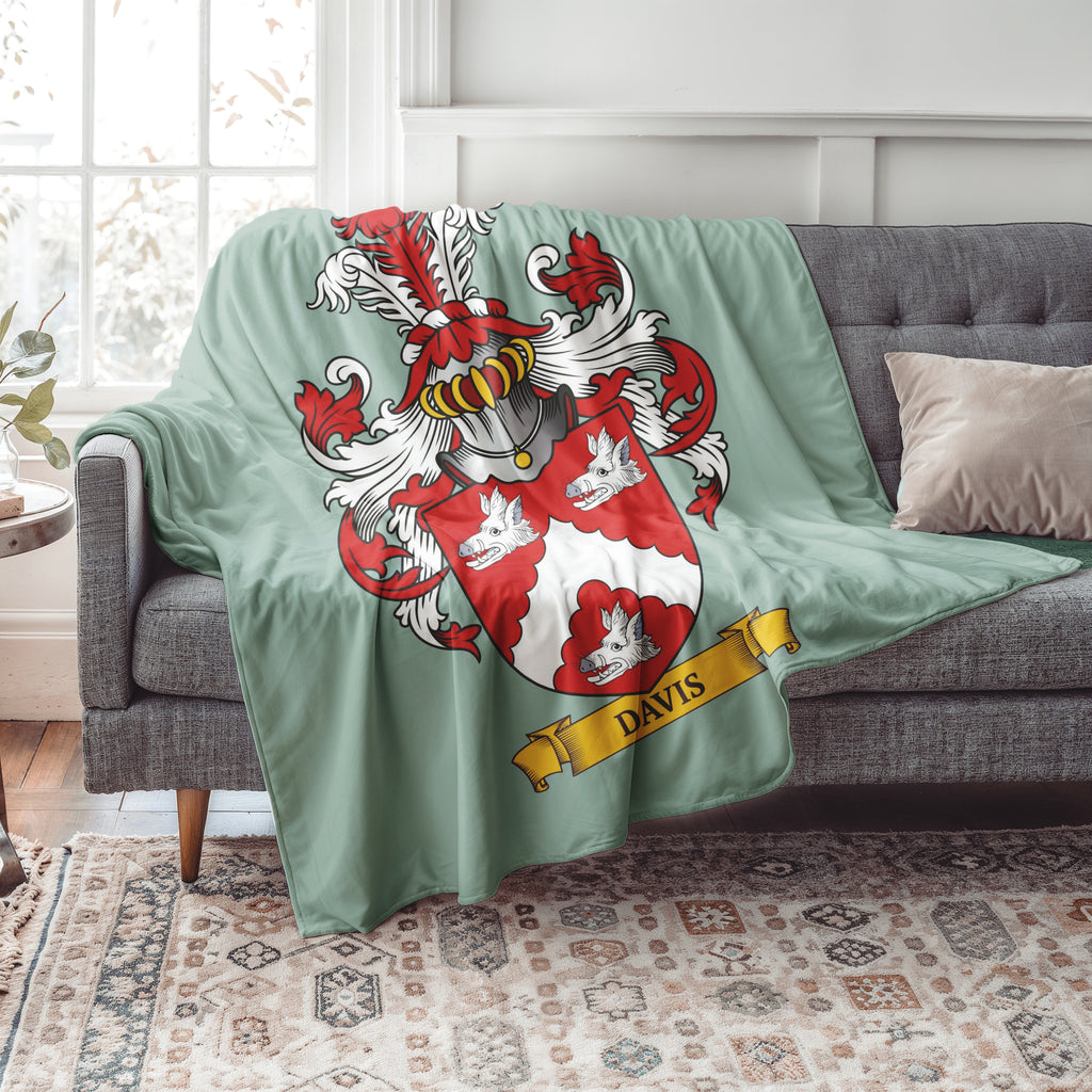Personalized Green blanket with a family crest and 'Davis' family crest  draped over a gray sofa in a living room.