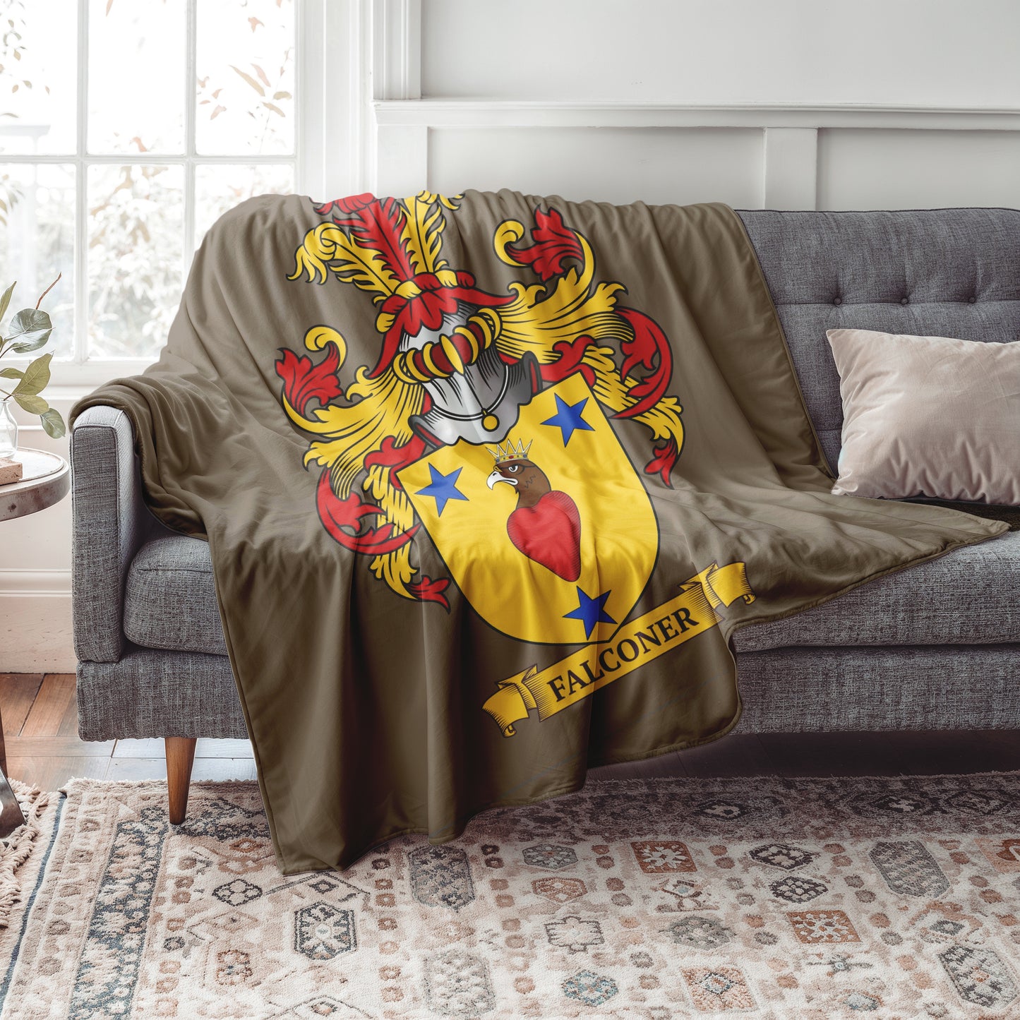 Personalized brown Blanket with a colorful family crest draped over a gray sofa in a living room.
