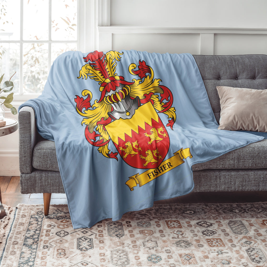Personalized pastel blue Blanket with a family crest design draped over a gray sofa in a living room.