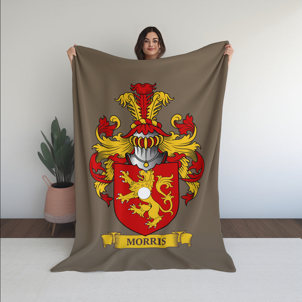 Woman holding a velveteen brown blanket with a red and yellow family crest