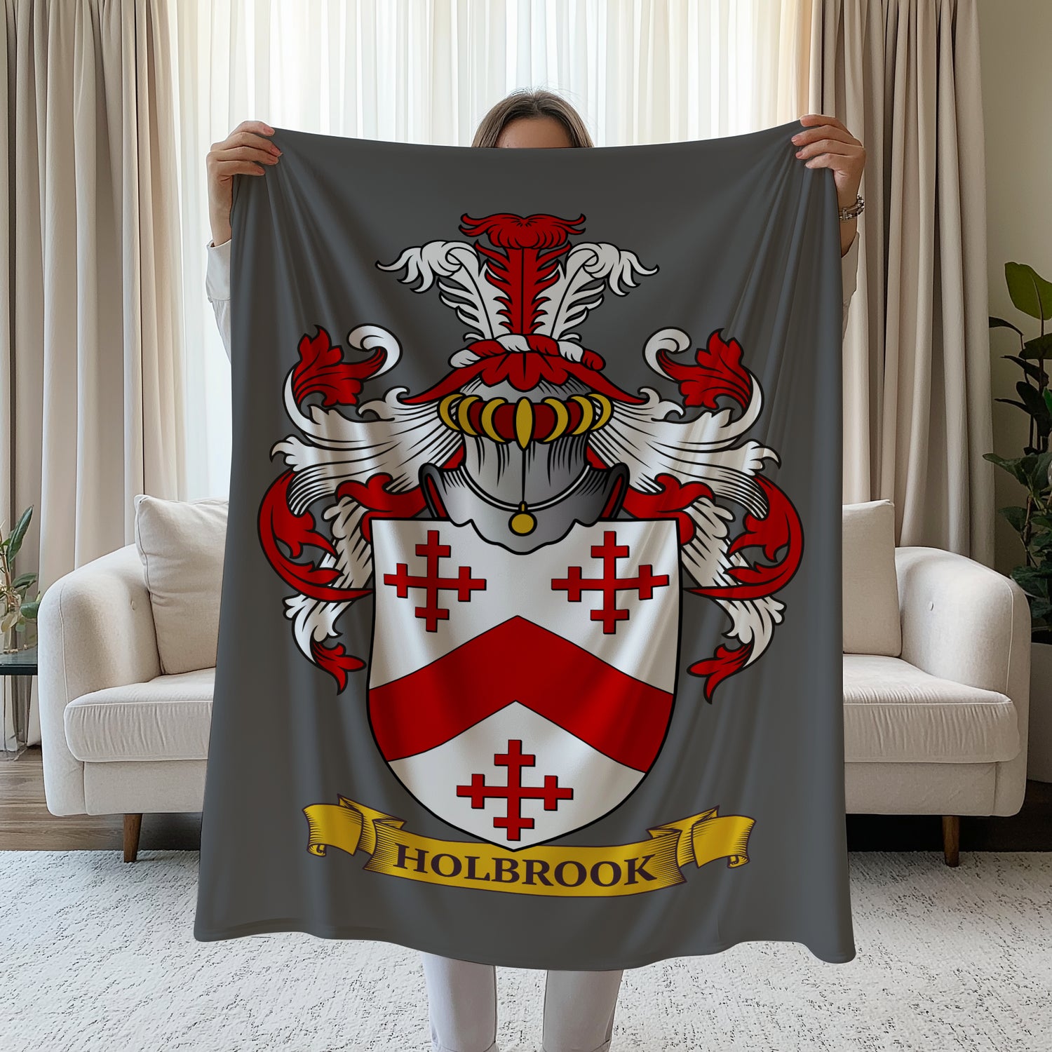 Person holding a Personalized velveteen gray blanket with a family crest, in a living room.