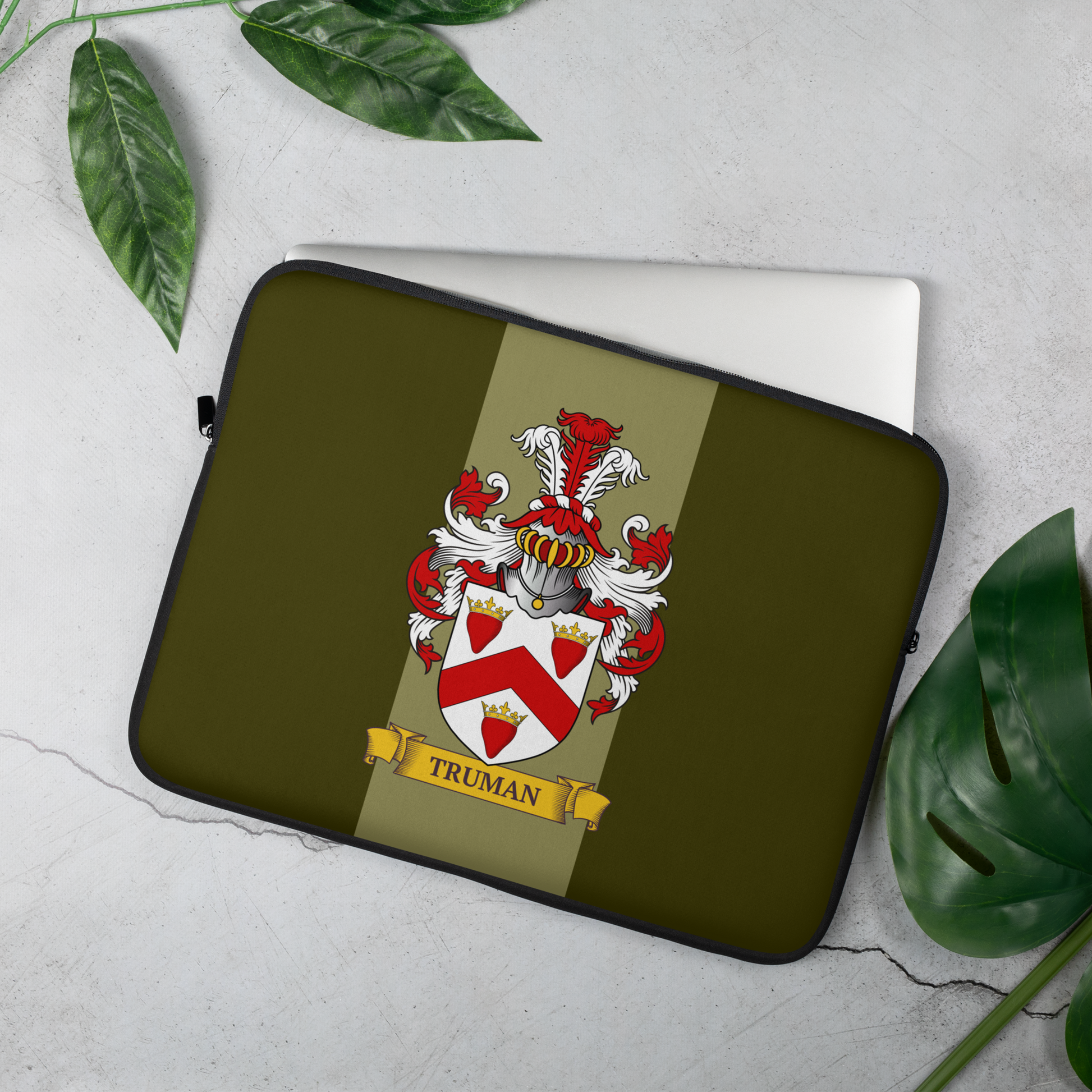 Green Laptop sleeve with a coat of arms design on a light gray background with green leaves.