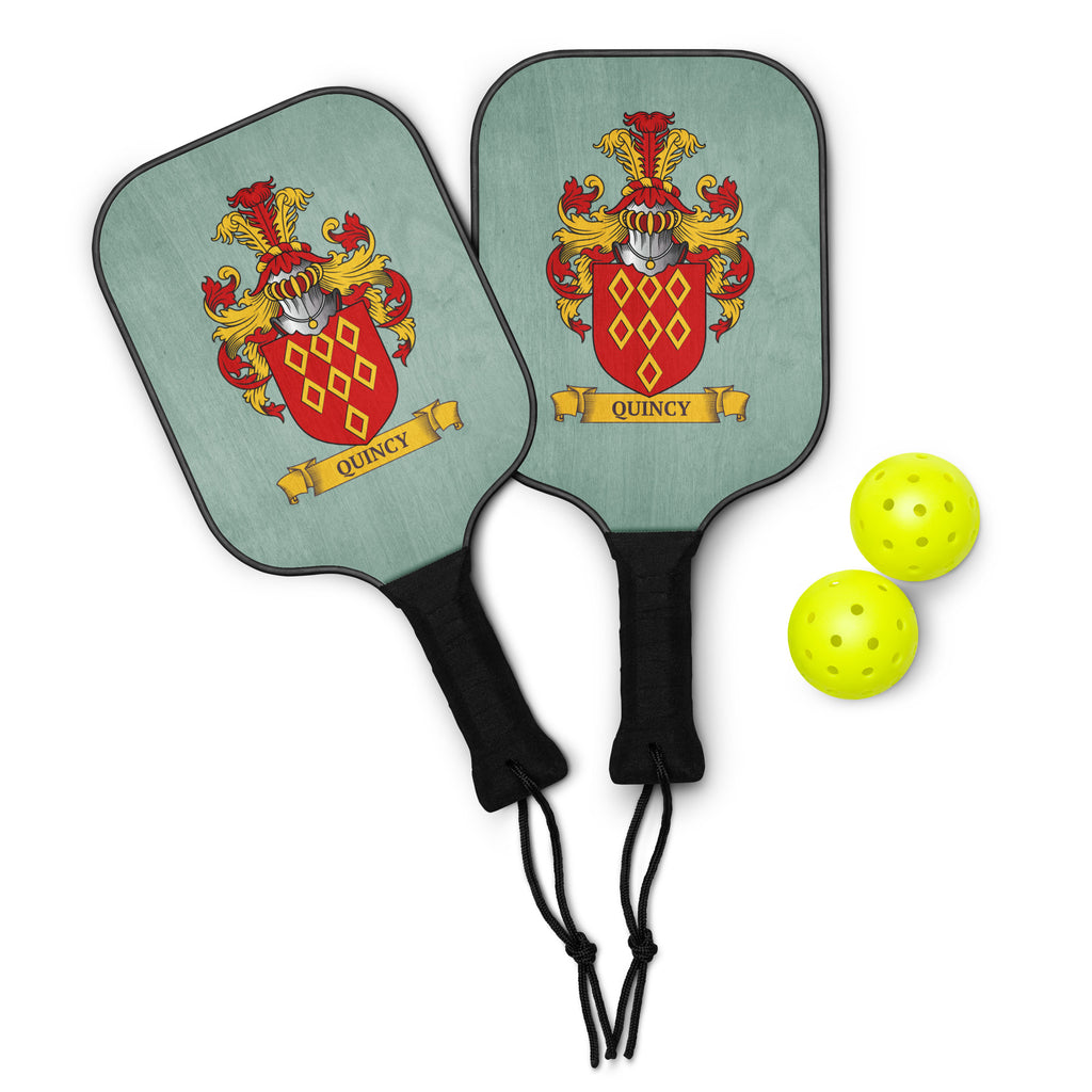 Two green family‑crest pickleball paddles shown together — each with a personalized crest and 2 green pickleballs nest to them.