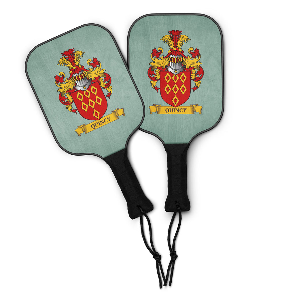 Two green pickleball paddles featuring a personalized family crest in them.