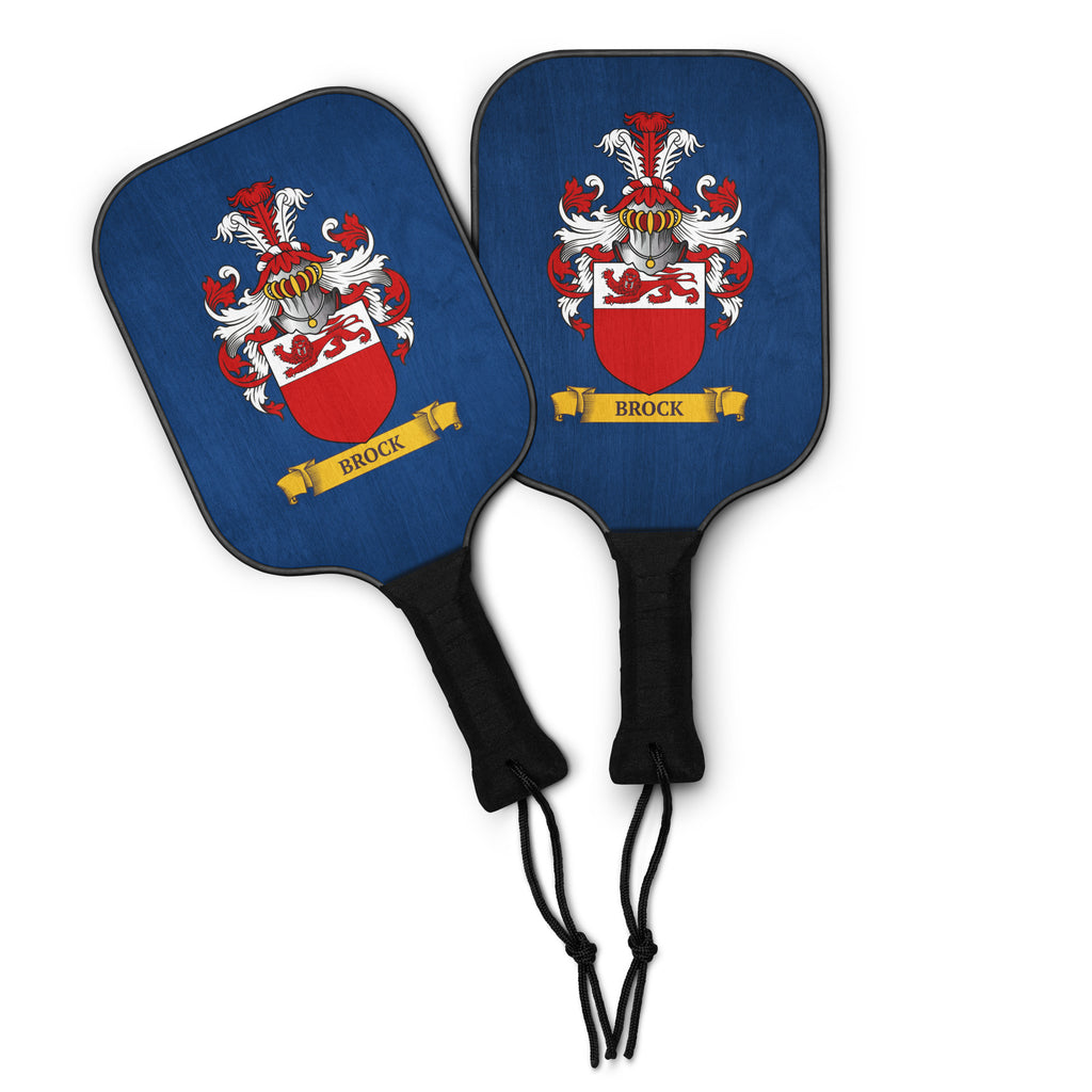 Two blue pickleball paddles with personalized family crest design on a white background