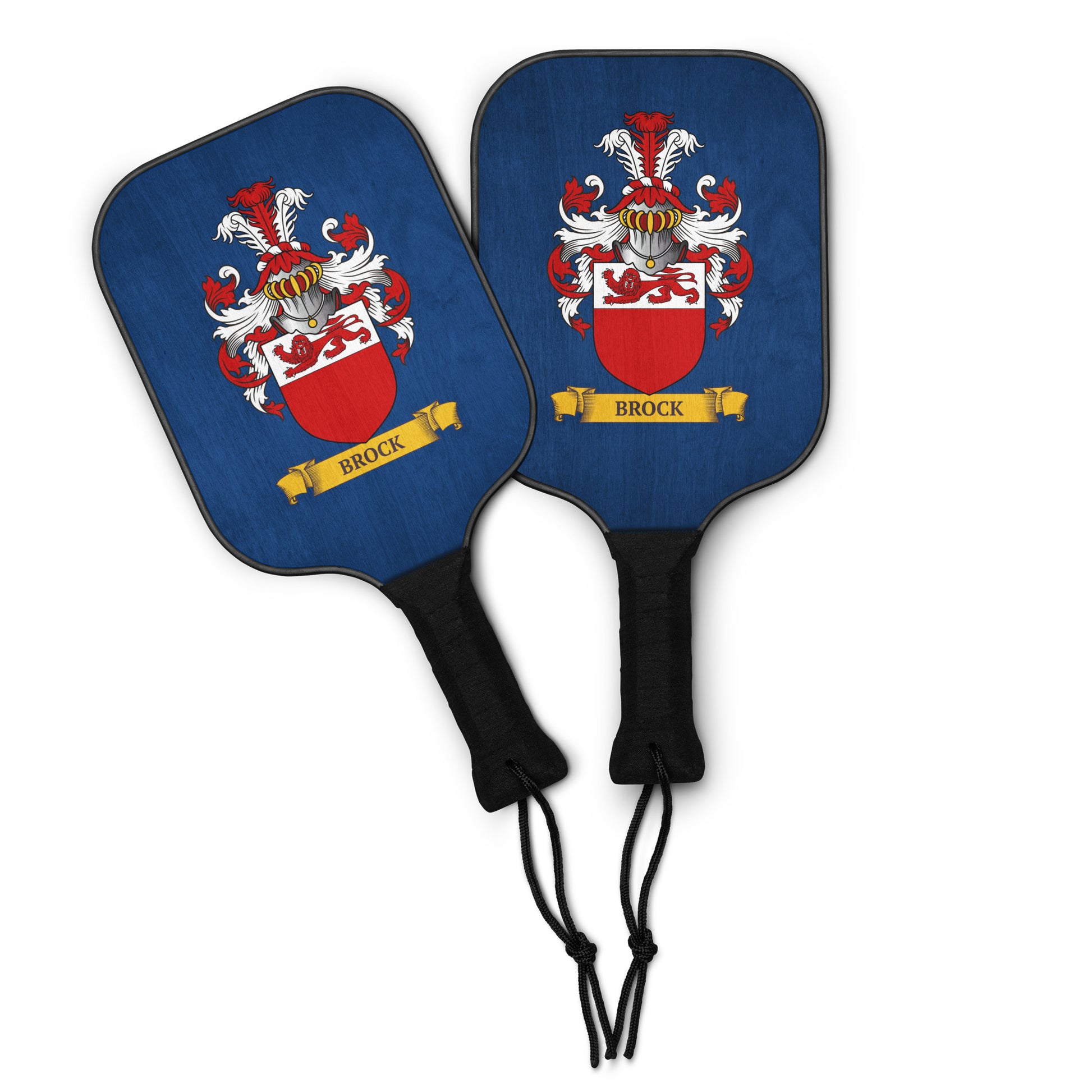 Two blue pickleball paddles with personalized family crest design on a white background